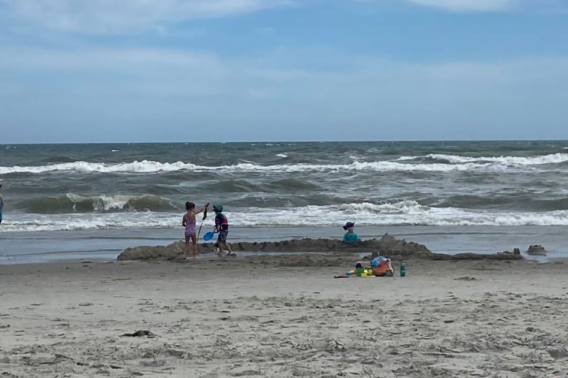 Chris and the kids tried to fortify this sandcastle throughout the day but eventually succumbed to the waves.