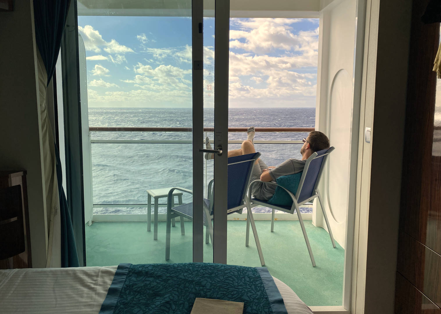 Chris relaxing on our balcony during our transatlantic cruise.